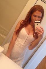 Buxom redhead in a white dress